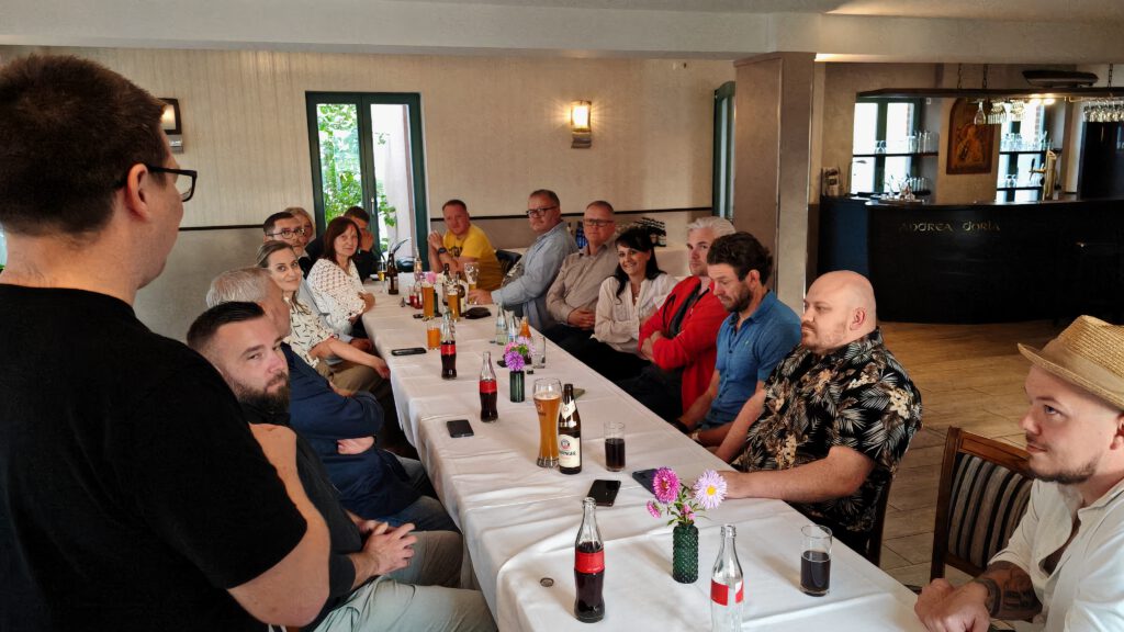Die Wirtschaftsjunioren Havelland mit Ilka Lenke an der langen Tafel im Gasthof Milow, vom stehenden Sprecher aus gesehen.